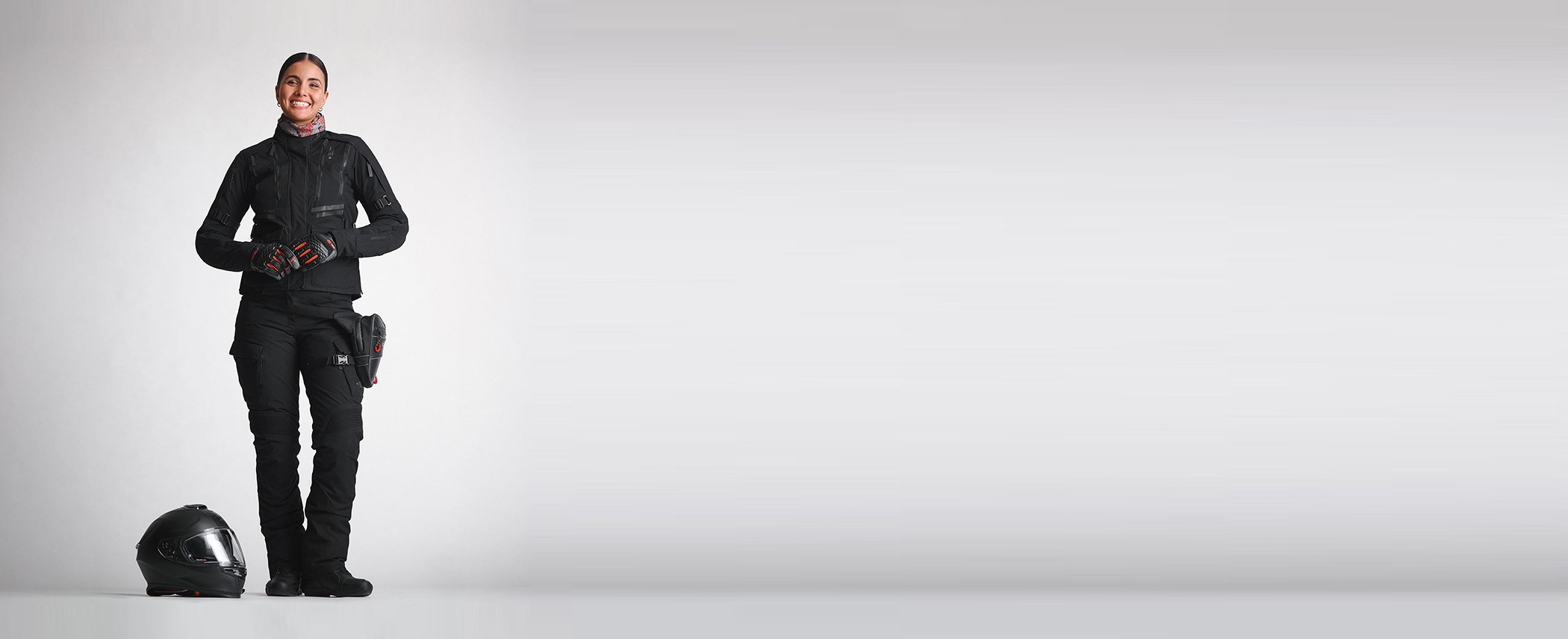 Motorradfahrerin stehend neben einem Helm