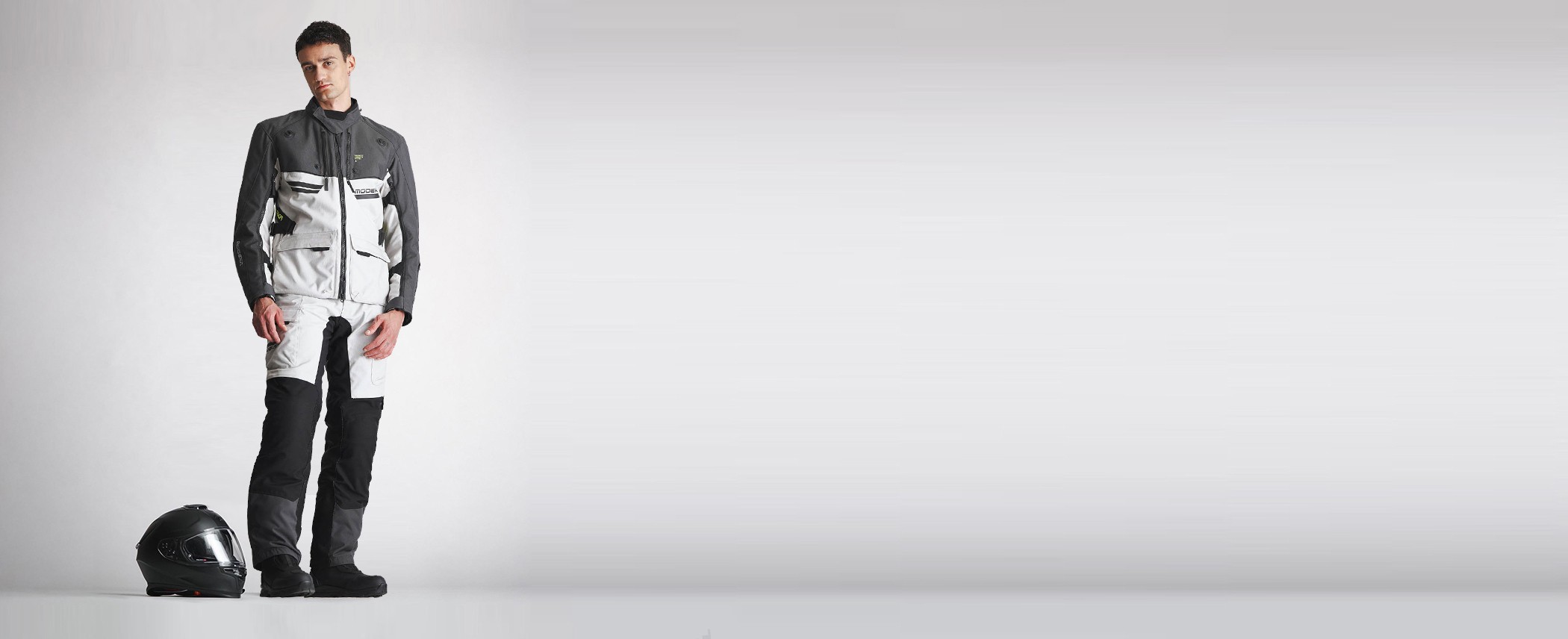 Motorradfahrer stehend neben einem Helm