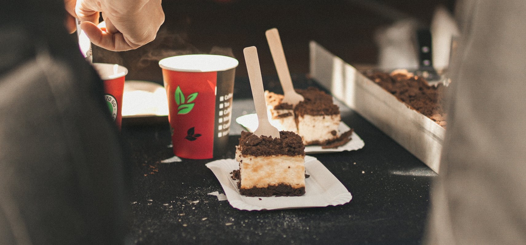 Kuchenstücke und rote Becher stehen auf einem Tisch bei dem Event.