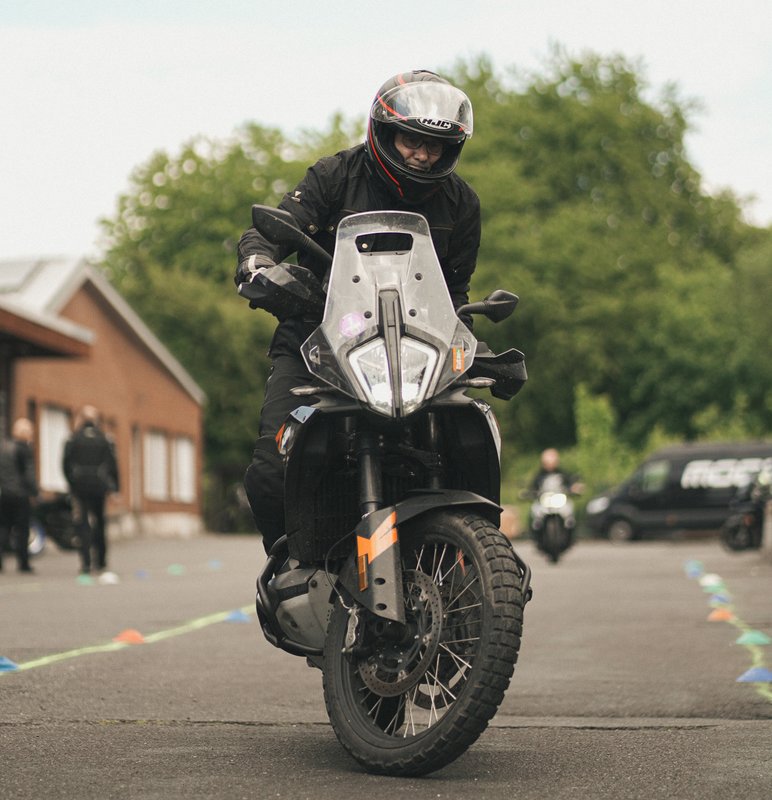 Motorradfahrer fährt auf einem markierten Parcours direkt auf die Kamera zu.